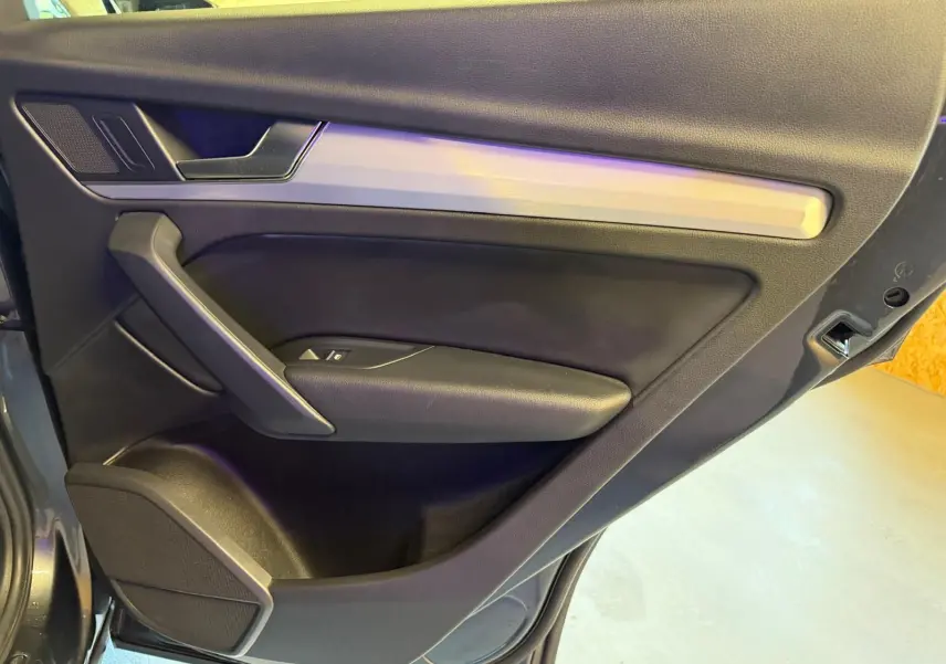 Vue rapprochée de la porte arrière droite de l’Audi Q5 Sportback gris, avec garniture noire et insert argenté.