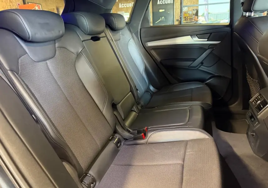 Vue intérieure côté droit des sièges arrière en cuir noir de l'Audi Q5 Sportback 2019, avec appuie-têtes et porte arrière visible.