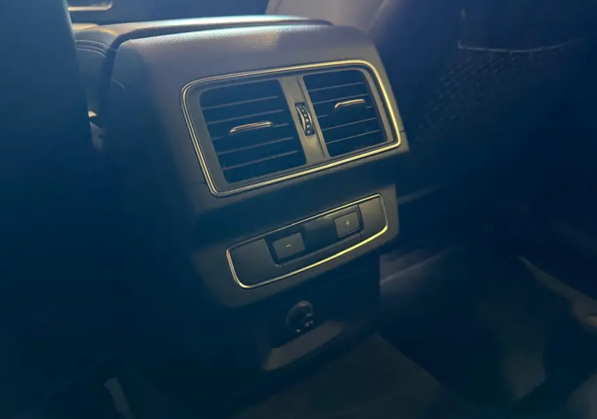 Détail de la console arrière avec bouches d’aération et commandes de climatisation dans l’Audi Q5 Sportback gris.