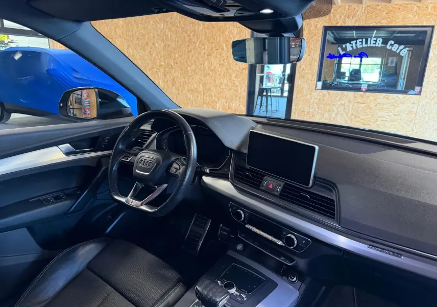 Vue intérieure côté conducteur de l'Audi Q5 Sportback gris, avec tableau de bord moderne et écran central tactile.
