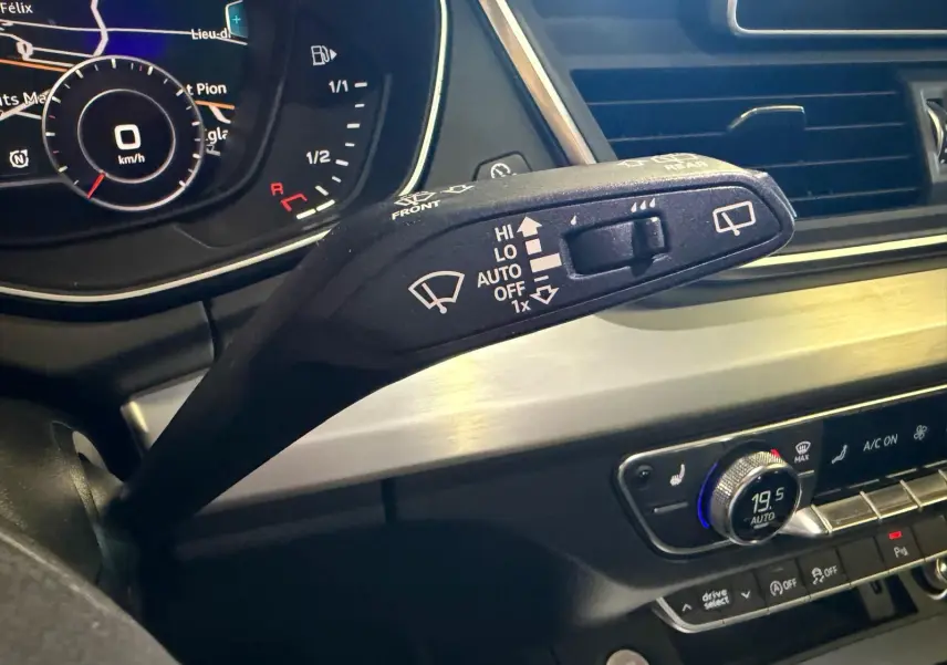 Gros plan sur la commande d’essuie-glace à gauche du volant dans l’habitacle gris d’un Audi Q5 Sportback 2019.