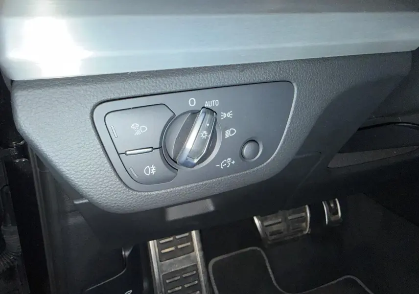 Gros plan sur le sélecteur d’éclairage et les pédales en aluminium de l’Audi Q5 Sportback gris, intérieur côté conducteur.