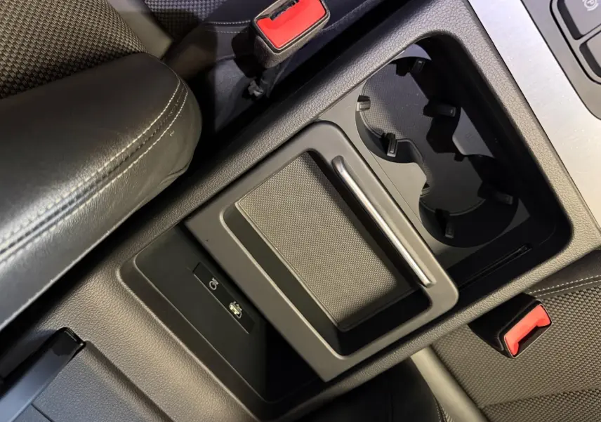 Gros plan sur la console centrale noire de l’Audi Q5 Sportback 2019, avec porte-gobelets et ports USB visibles.