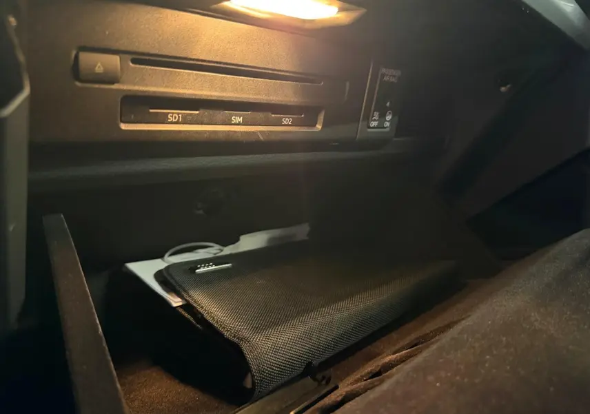 Gros plan sur la boîte à gants ouverte de l'Audi Q5 Sportback 2019 avec pochette noire et éclairage intérieur.