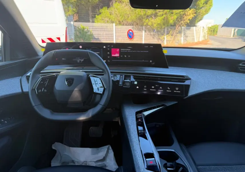 Vue intérieure du tableau de bord et volant du Peugeot 3008 Hybrid 145 Allure 2025, avec écran tactile et finitions grises.