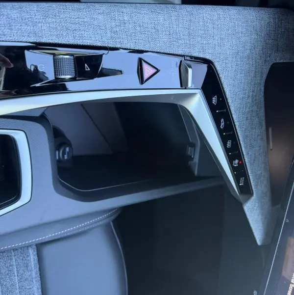 Détail de la console centrale du Peugeot 3008 Hybrid 145 e-DCS6 Allure 2025, avec finition tissu gris et commandes tactiles.