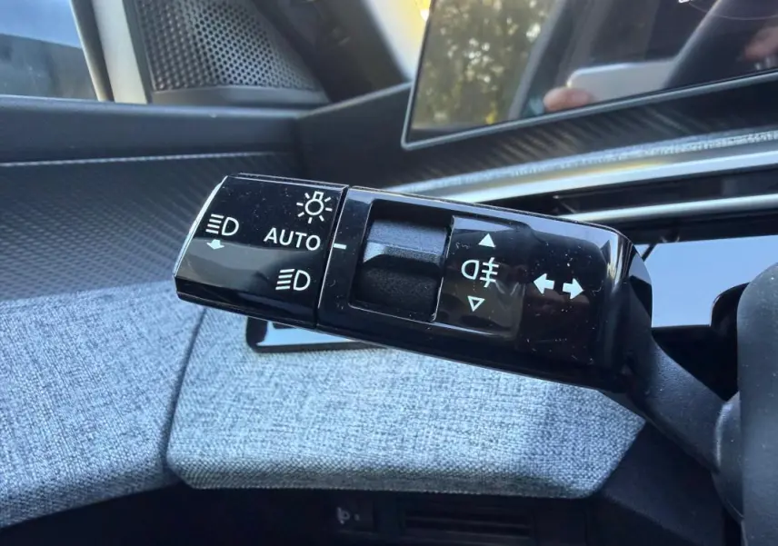 Gros plan sur la commande des feux et clignotants du Peugeot 3008 Hybrid 145 e-DCS6 Allure 2025, intérieur gris.