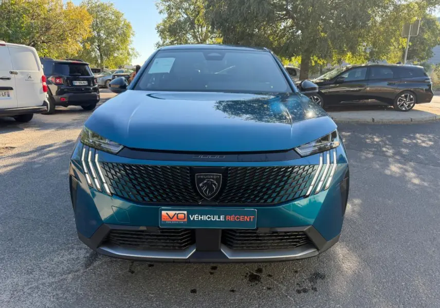Vue avant d’un Peugeot 3008 Hybrid 145 e-DCS6 Allure bleu 2025 avec calandre noire et feux LED distinctifs.