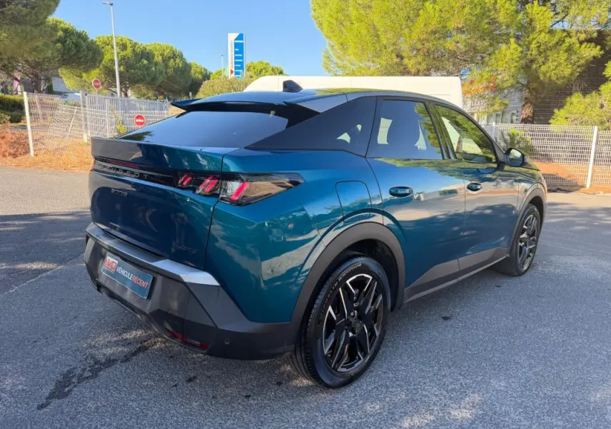 Peugeot 3008 Hybrid bleu 3/4 arrière droit, feux arrière à griffes et jantes noires distinctives.