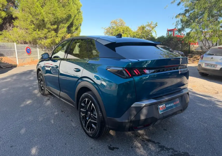 Vue 3/4 arrière droite du Peugeot 3008 Hybrid 145 e-DCS6 Allure bleu 2025 avec feux arrière distinctifs en forme de griffes.
