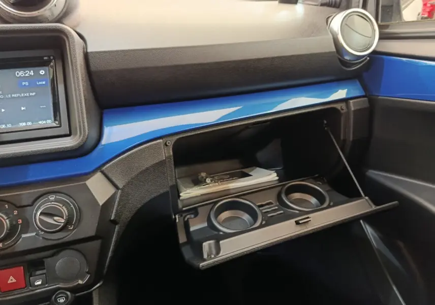Intérieur de l'AIXAM AMBITION 0.5 CITY COUPE GTI 2023, vue sur la boîte à gants ouverte avec bandeau bleu et console centrale.