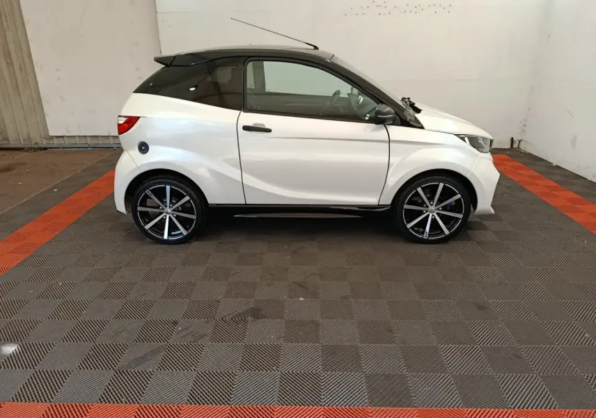 Vue de profil côté gauche d'une Aixam Ambition 0.5 City Coupe GTI blanche avec toit noir et jantes noires.