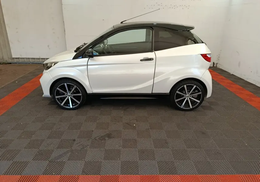 Vue de profil côté gauche d'une Aixam Ambition 0.5 City Coupe GTI blanche avec jantes noires et rétroviseur conducteur noir.