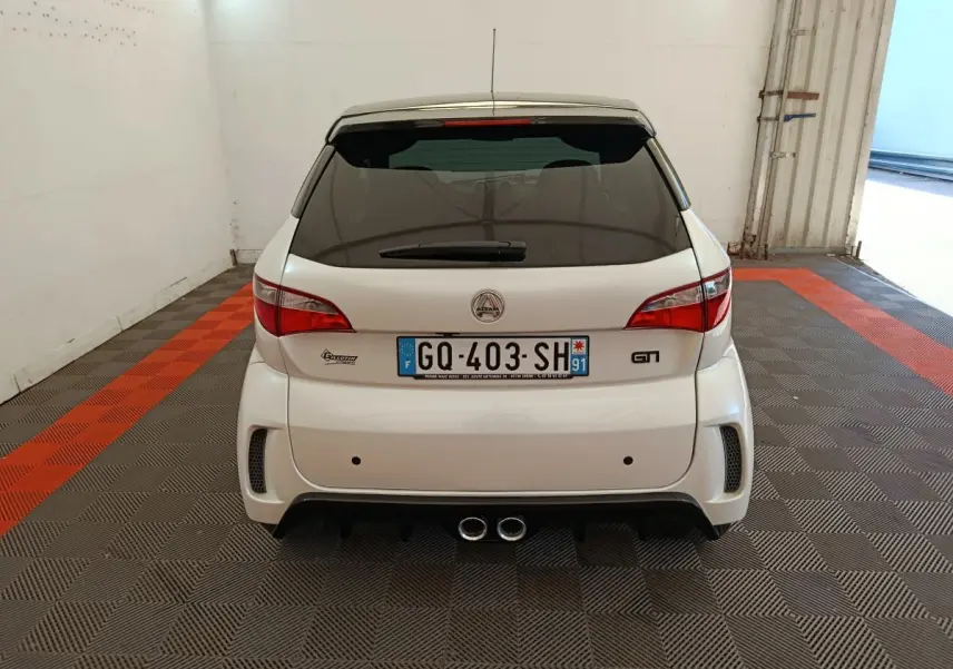 Vue arrière d'une Aixam Ambition 0.5 City Coupe GTI blanche 2023 avec double sortie d'échappement centrale et lunette arrière teintée.