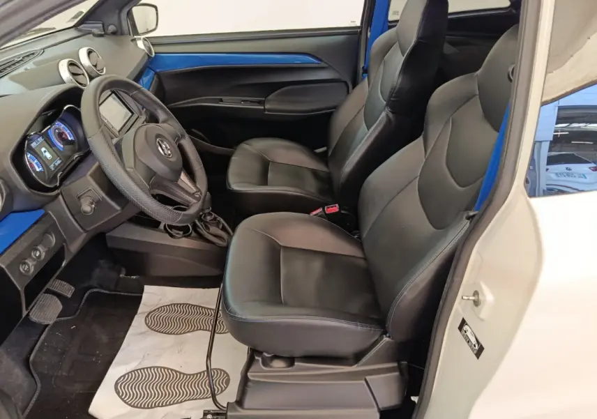 Vue intérieure côté conducteur de l'AIXAM Ambition 0.5 City Coupe GTI 2023, sièges noirs et tableau de bord bleu.