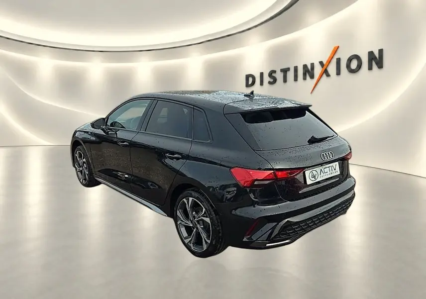 Audi A3 Sportback noir Mythos vue 3/4 arrière droit dans un showroom lumineux avec jantes alu distinctives.