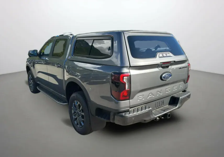 Ford Ranger gris carbone en 3/4 arrière droit avec hardtop vitré et jantes alu 18 pouces visibles.