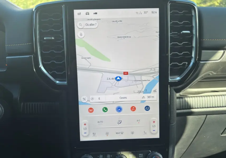 Vue rapprochée de la console centrale du Ford Ranger Wildtrak 2026 avec écran tactile GPS et aérateurs hexagonaux noirs.