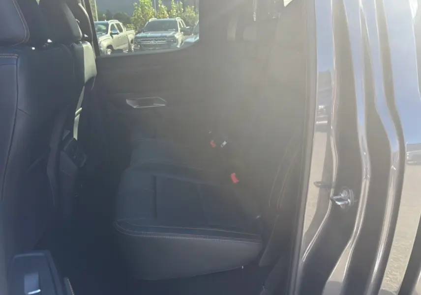 Vue intérieure côté arrière droit du Ford Ranger 2026 gris carbone, montrant les sièges arrière en cuir avec surpiqûres contrastantes.