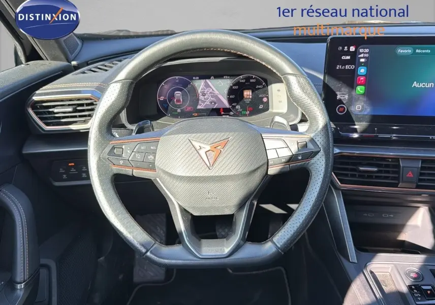 Vue intérieure centrée sur le volant en cuir noir perforé du CUPRA Formentor 1.4 E-HYBRID 2023 avec tableau de bord numérique.