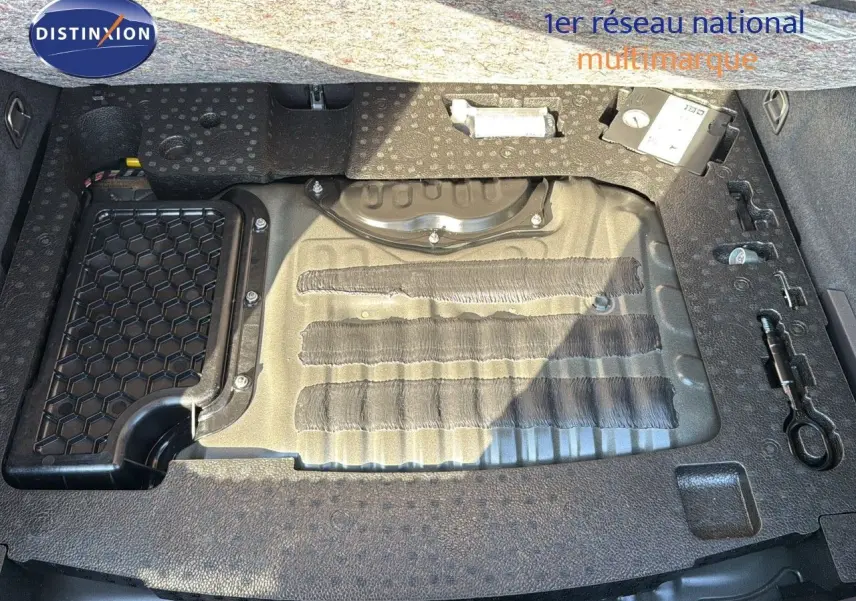 Vue plongeante sur le coffre ouvert d'une CUPRA Formentor noir minuit, montrant le rangement sous plancher et outils intégrés.