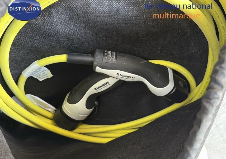 Câble de recharge jaune Mennekes enroulé dans le coffre d'un CUPRA Formentor noir minuit hybride rechargeable.