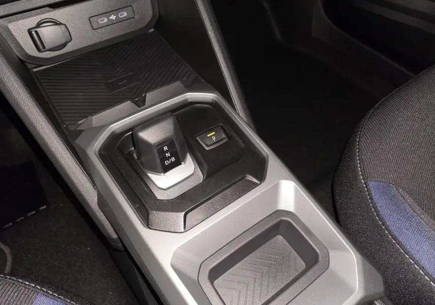 Vue rapprochée de la console centrale du Dacia Duster 2025 noir, montrant le levier de boîte auto et un rangement.