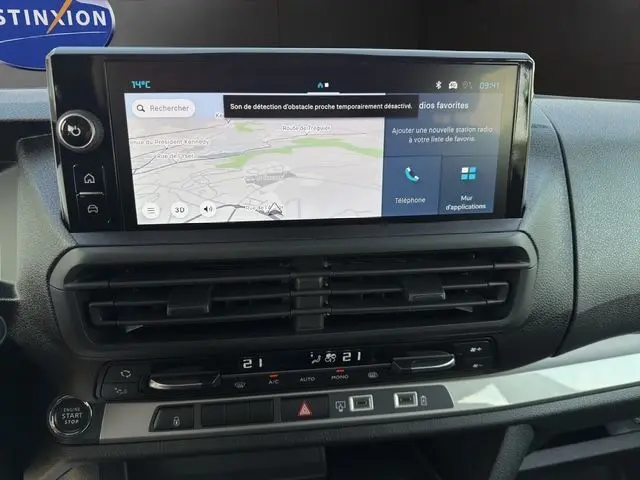 Vue rapprochée de l’écran tactile et de la console centrale du Citroën Jumpy blanc, avec commandes clim et bouton start/stop visibles.