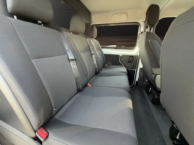 Vue intérieure côté droit de la banquette arrière grise du Citroën Jumpy Cabine Approfondie blanc avec sièges tissu et ceintures de sécurité.