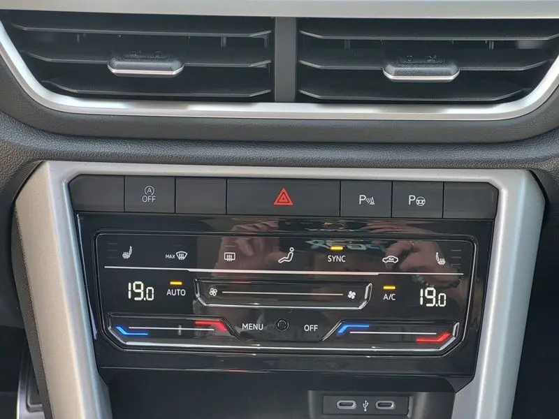 Vue rapprochée du tableau de bord du Volkswagen T-Roc 2025 gris Indium, montrant la commande de climatisation digitale.