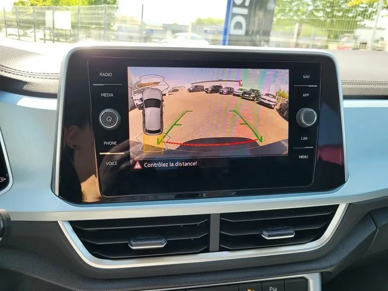 Écran central du Volkswagen T-Roc 2025 montrant la caméra de recul avec guidage de trajectoire, intérieur gris clair.