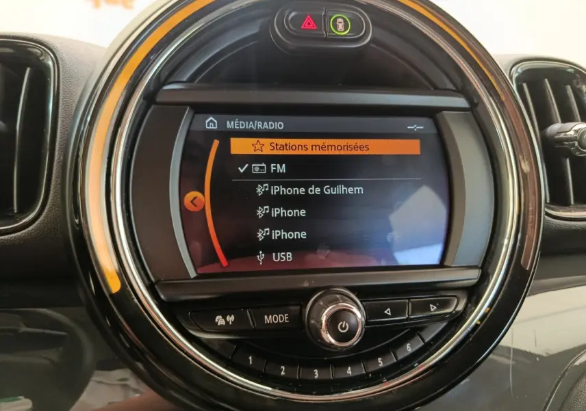 Écran central rond du tableau de bord MINI Countryman 2019 affichant les options média et radio, vue de face.