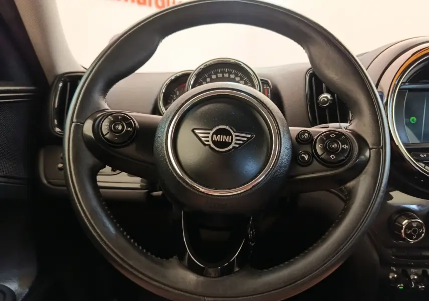 Vue rapprochée du volant cuir noir de la MINI Countryman 2019 avec commandes multifonctions et tableau de bord visible.