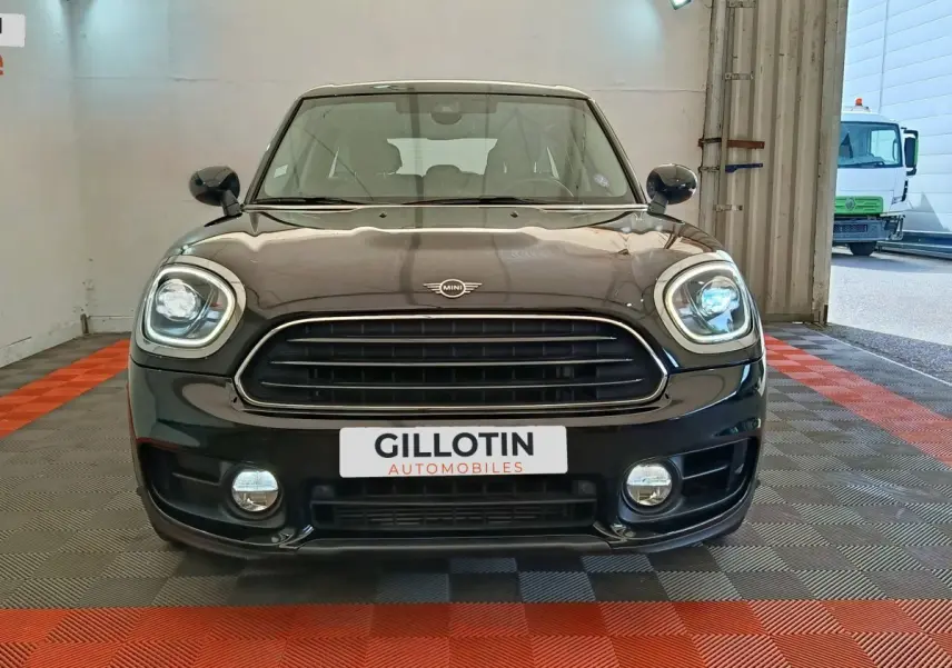 Vue frontale d’un MINI Countryman noir 2019 avec phares LED et calandre noire brillante dans un garage.