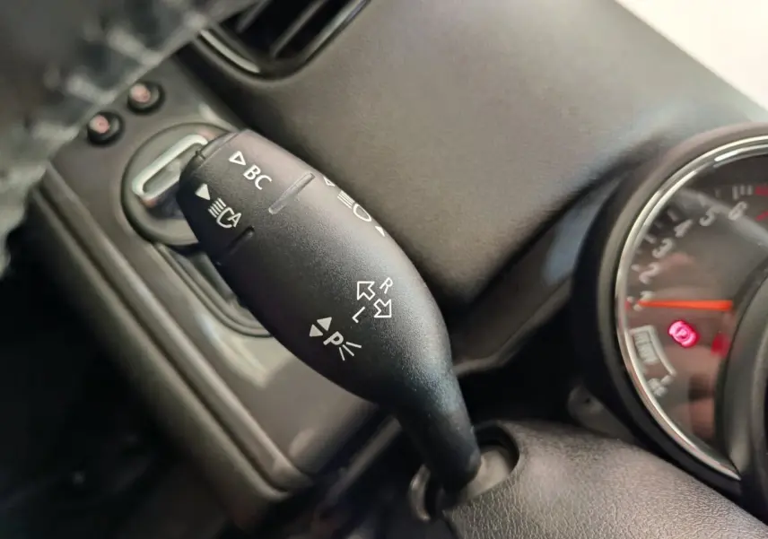 Gros plan sur la manette de clignotant et commandes au volant d'une MINI Countryman noire, tableau de bord partiellement visible.