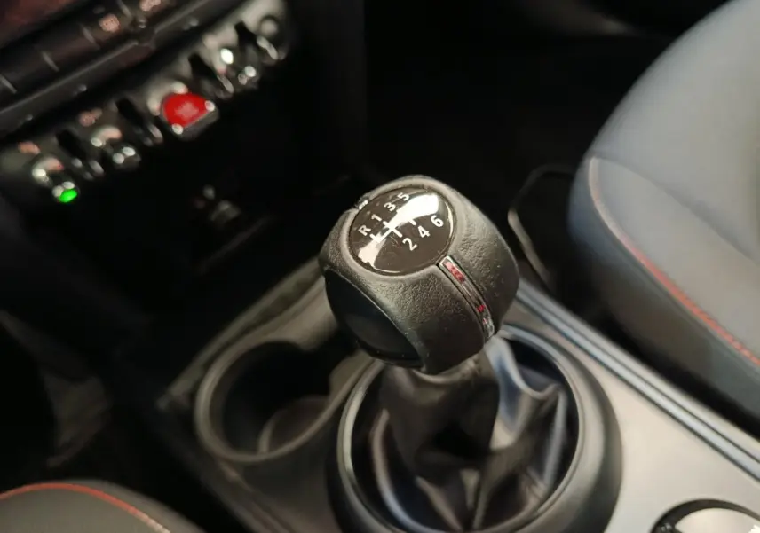 Gros plan sur la commande de boîte manuelle 6 vitesses de la MINI Countryman noire, avec console et siège partiellement visibles.