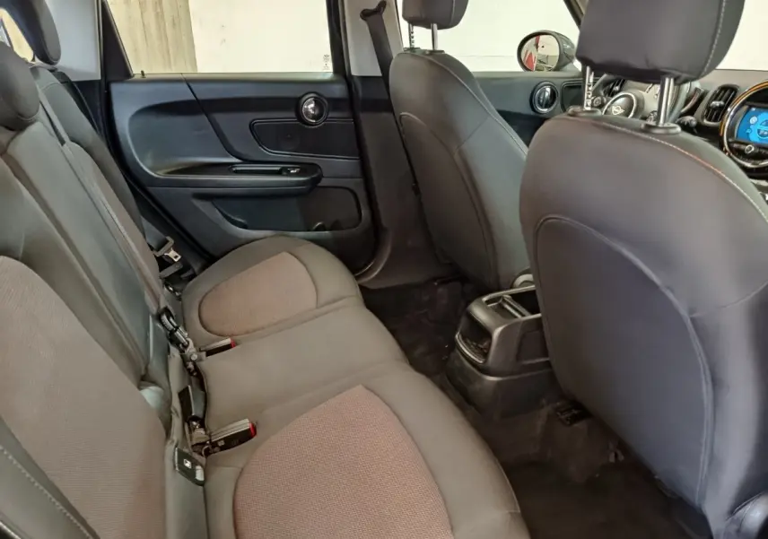 Vue intérieure arrière côté gauche du MINI Countryman 2019, sièges tissu noir et console centrale visible.