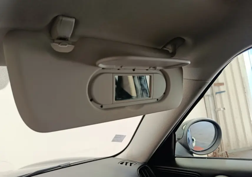 Détail du pare-soleil avec miroir intégré côté conducteur dans une MINI Countryman noire, vue intérieure avant droite.