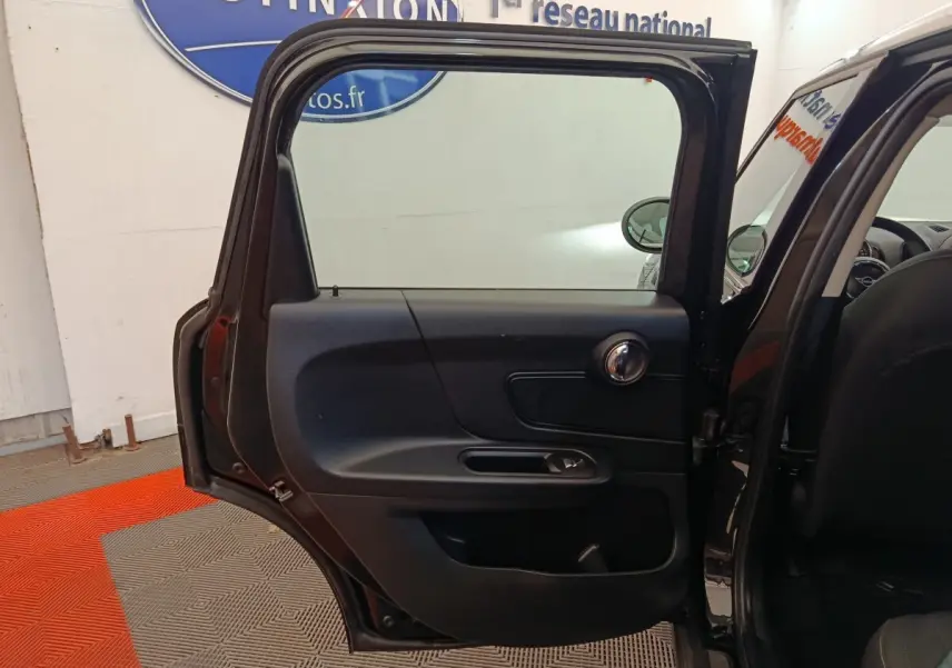 Vue intérieure de la porte arrière gauche noire ouverte d'une MINI Countryman 2019 dans un showroom.