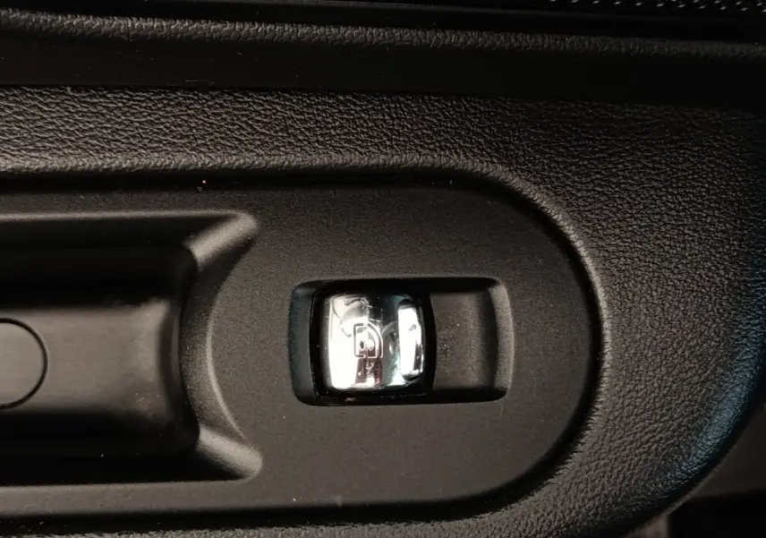 Gros plan sur le bouton d'ouverture électrique du coffre dans l'habitacle noir d'une MINI Countryman 2019.