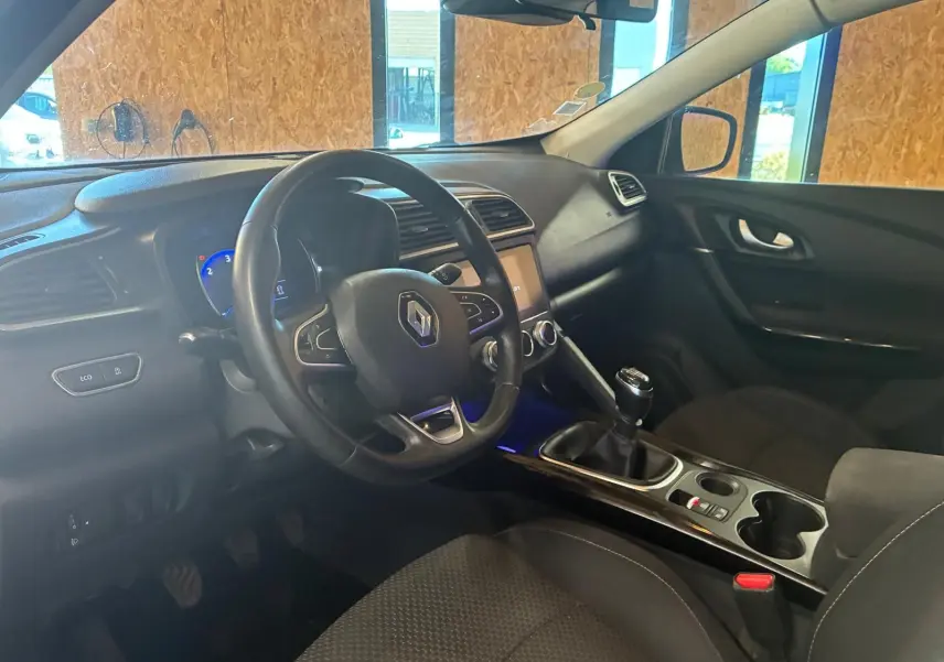 Vue intérieure côté conducteur du Renault Kadjar gris 2019, volant multifonction et boîte manuelle visibles.