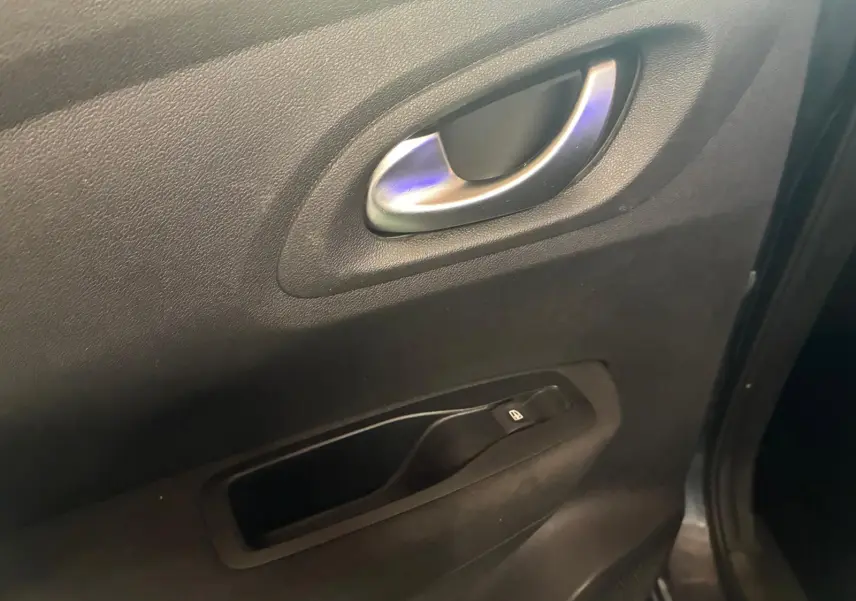 Poignée intérieure de porte côté gauche en tissu noir sur Renault Kadjar gris, version 2019, avec bouton de commande de vitre.