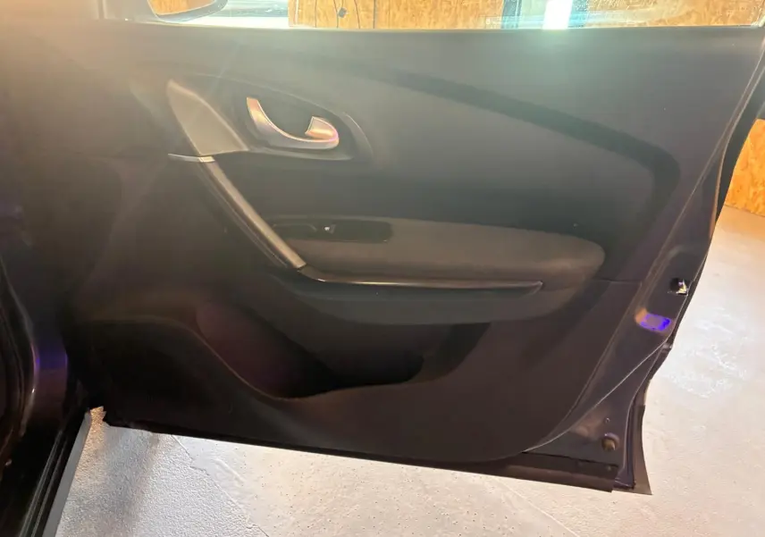Vue intérieure de la porte avant gauche du Renault Kadjar 2019, avec garniture noire et poignée argentée.