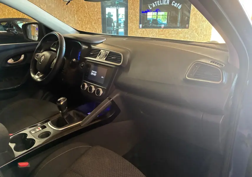 Vue intérieure côté conducteur du Renault Kadjar gris 2019, montrant le tableau de bord et la console centrale avec boîte manuelle.