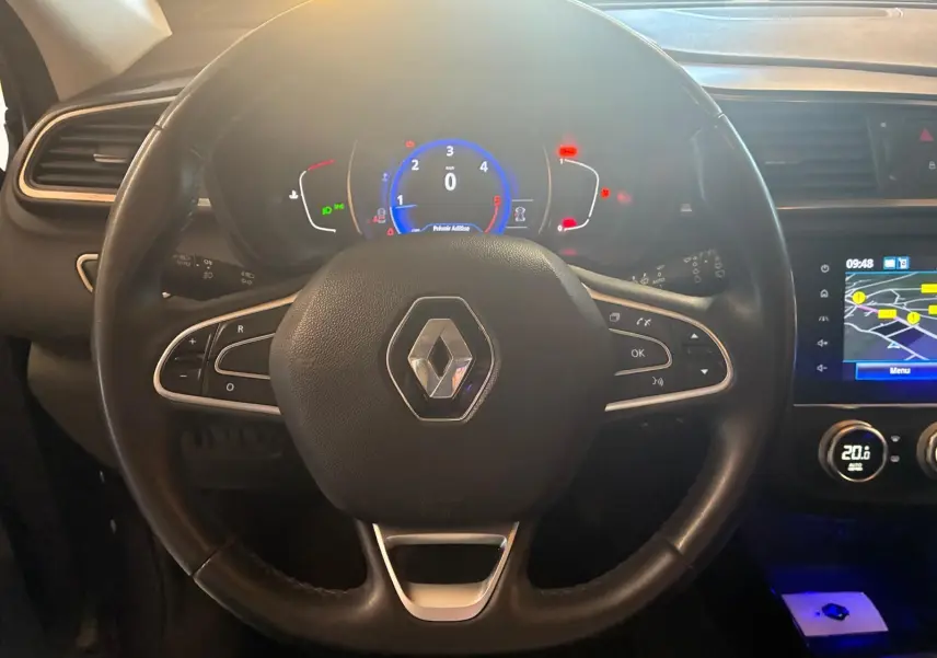 Vue rapprochée du volant noir et du tableau de bord digital du Renault Kadjar gris de 2019 avec écran GPS allumé.