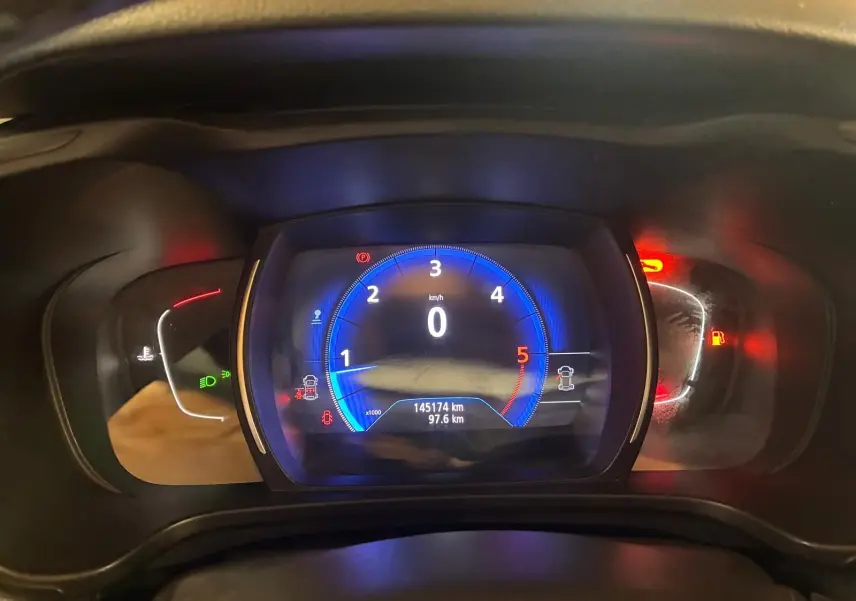 Vue rapprochée du tableau de bord numérique du Renault Kadjar 1.5 BlueDCI 115, affichage bleu et indicateurs rouges allumés.