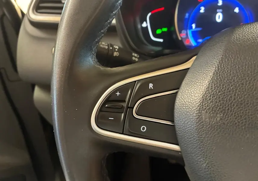 Gros plan sur le volant noir du Renault Kadjar 2019 avec commandes intégrées et tableau de bord éclairé en bleu.