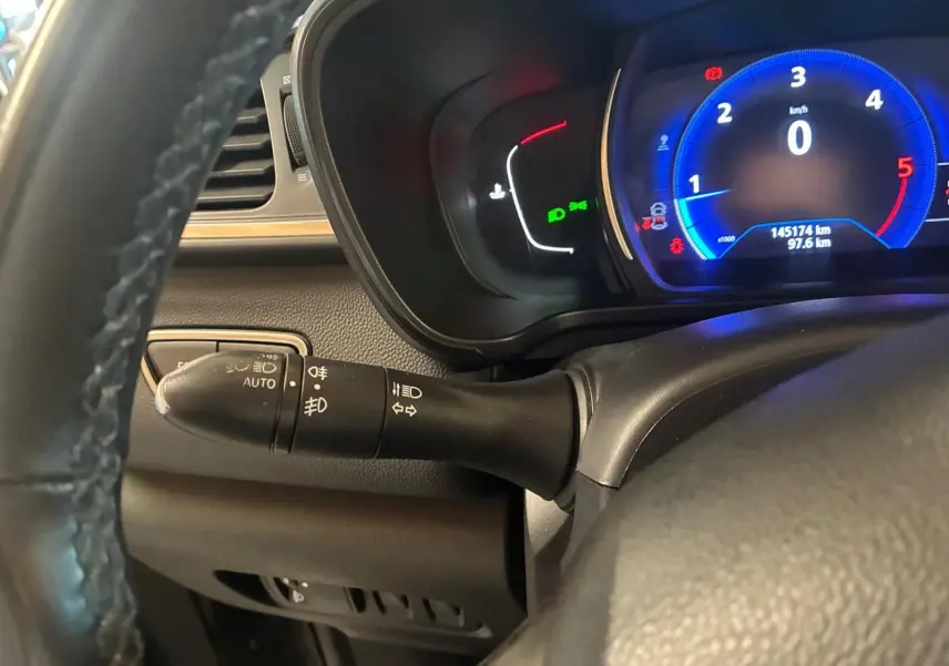 Vue rapprochée du tableau de bord côté gauche du Renault Kadjar gris, affichant le compteur digital et la commande des phares.