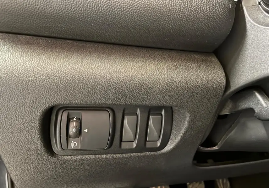 Gros plan sur les commandes de réglage des phares et des rétroviseurs côté conducteur du Renault Kadjar gris 2019.