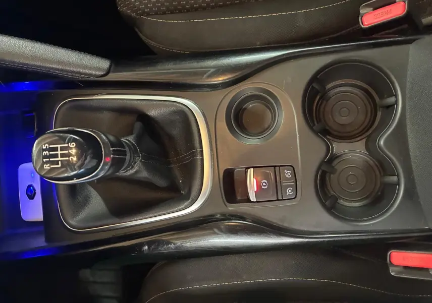 Vue plongeante sur la console centrale du Renault Kadjar gris, mettant en valeur le levier de vitesses manuel et les porte-gobelets.